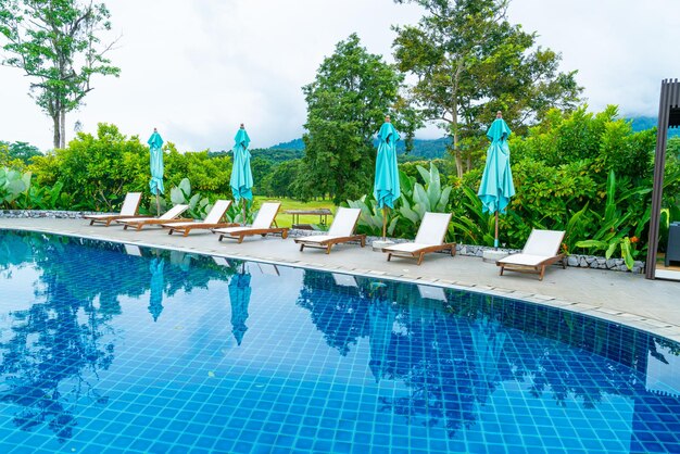 Photo pool bed around swimming pool with mountain hill background