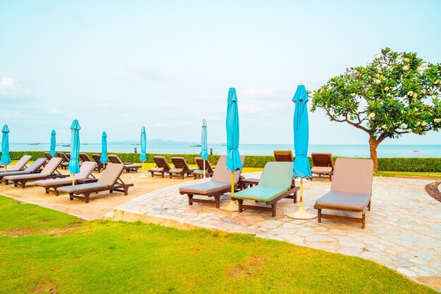 pool beds and umbrellas around swimming pool by the sea