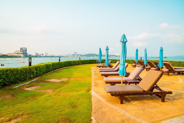 Pool chairs and umbrella around swimming pool