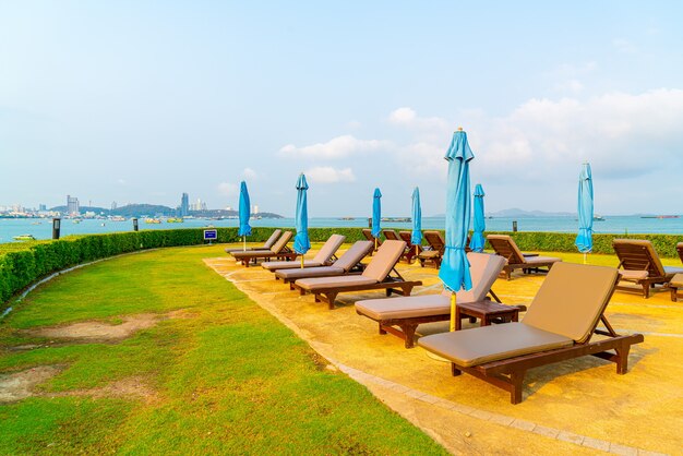 Pool chairs and umbrella around swimming pool