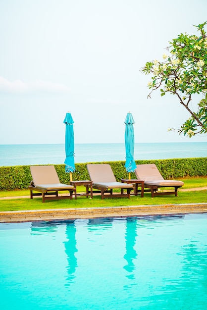 pool chairs with umbrella around swimming pool