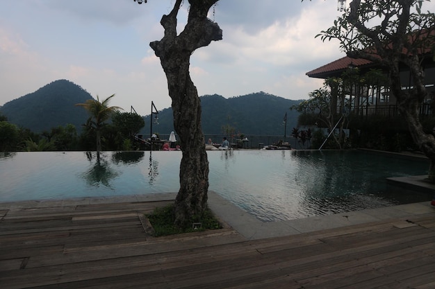 The pool at the resort is surrounded by mountains and trees.