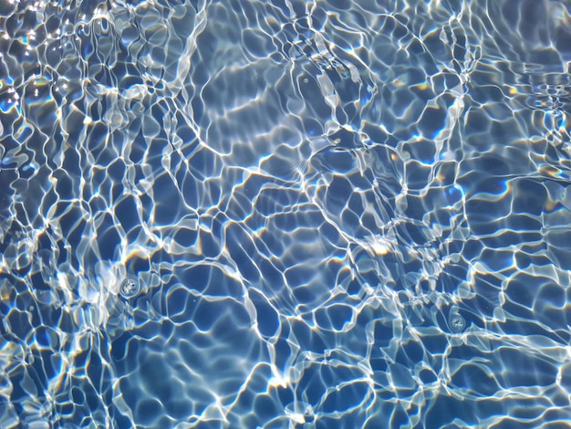 A pool with clear water and the sun reflecting on the water