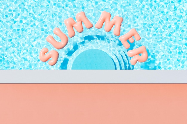 Pool with floating pink inflatable letters in sunlight