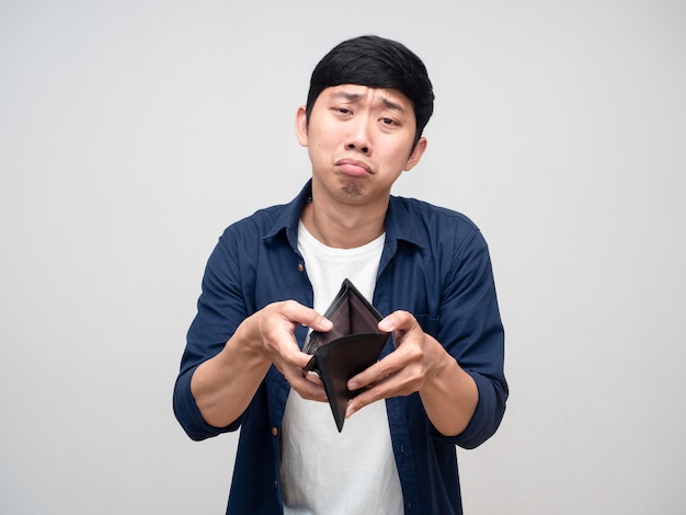 Poor asian man show empty wallet feels unhappy isolated