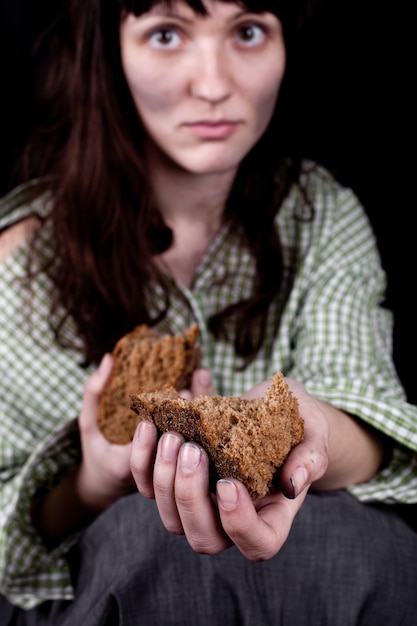 Foto povera donna mendicante con un pezzo di pane.