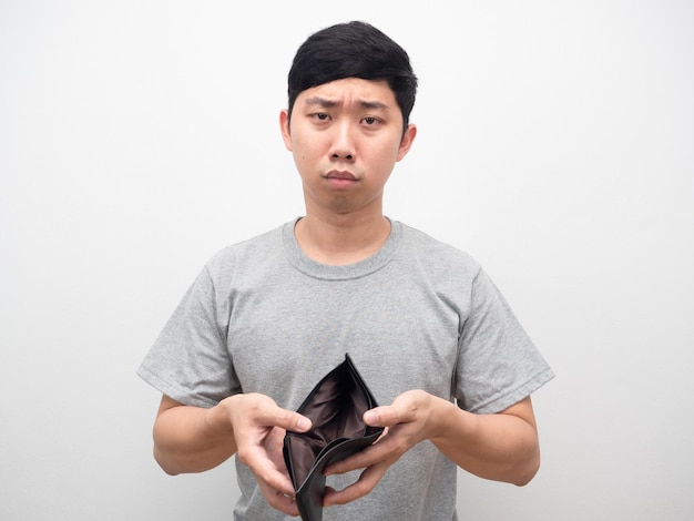 Poor man feel sad holding empty wallet no money portrait