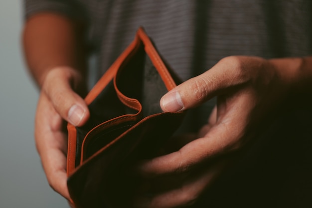 Poor man hand open empty wallet looking for money, broke, bankrupt concept