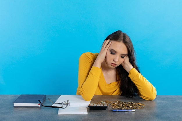 Photo a poor young girl counts money at home at her desk hoping that she will have enough for all expenses