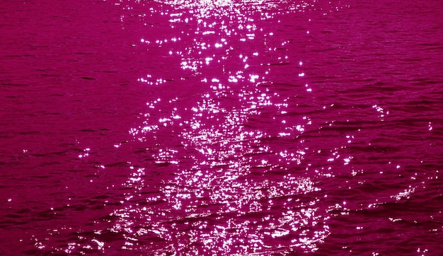 Photo pop art style magenta pink colored sparkling water surface with the sea ripples