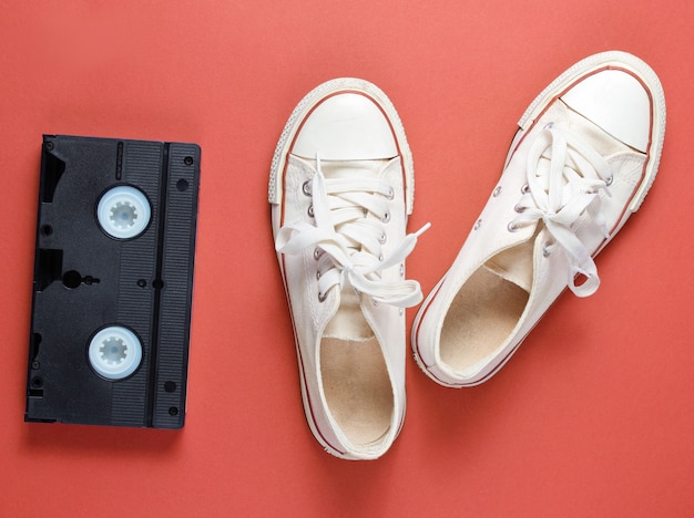 Pop culture attributes with retro white sneakers and videotape