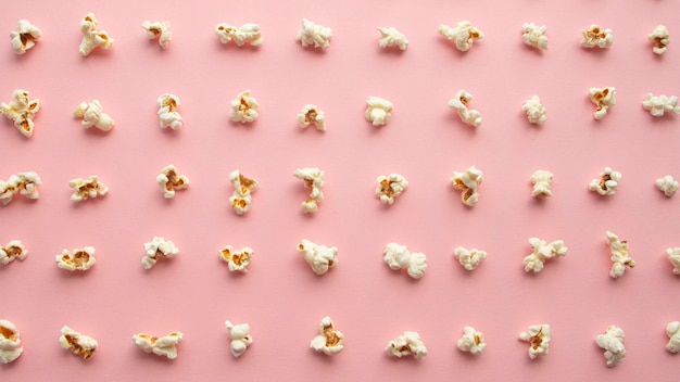 Popcorn arranged in order with a pattern on light pink background