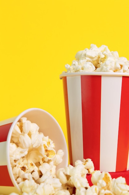 Popcorn big red white strip box cinema movie night pop corn\
food yellow background