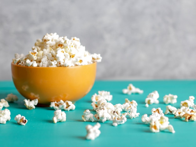 Popcorn in bowl on blue wood