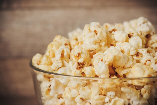 Photo popcorn in bowl on the wooden table selective focus