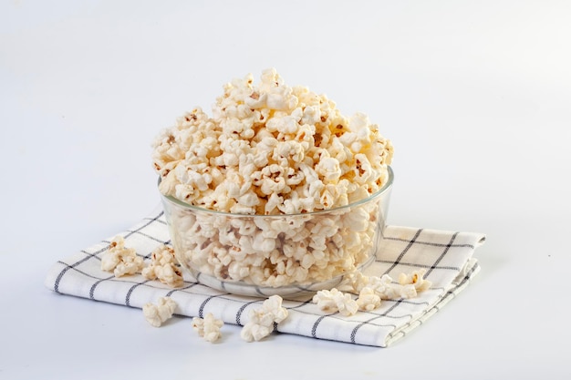 Popcorn in brown bowl on white background