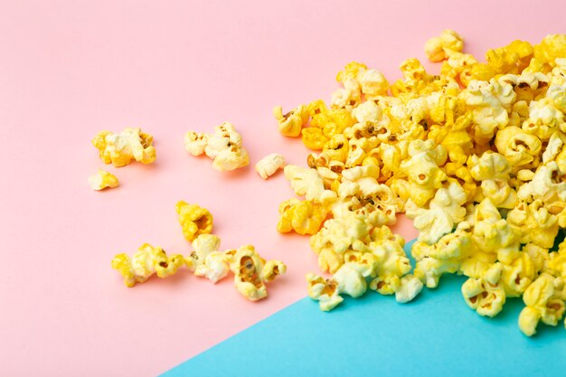 Popcorn on a colored background. Minimal food concept. Entertainment, film and video content. Aesthetics 80s and 90s concept