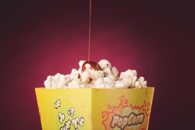 Foto popcorn die op rode achtergrond wordt geïsoleerd