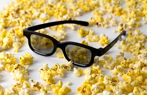 Popcorn en 3D-bril op witte tafel.