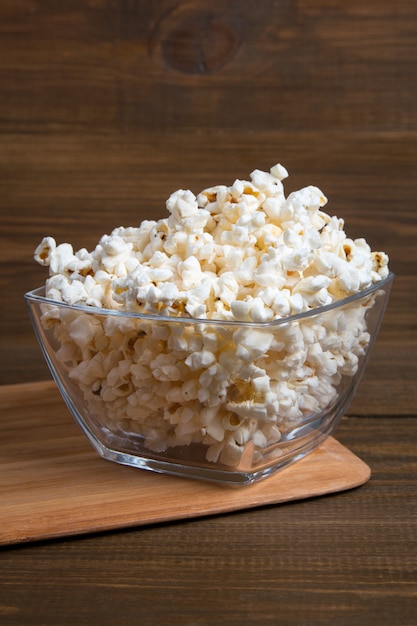 Popcorn in glass bowl on wooden