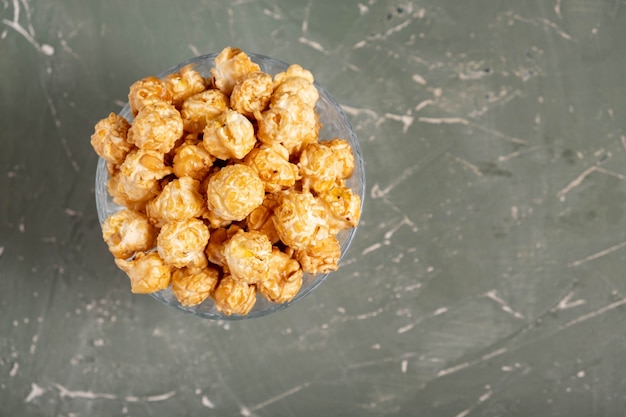 Popcorn in a glass on a green table