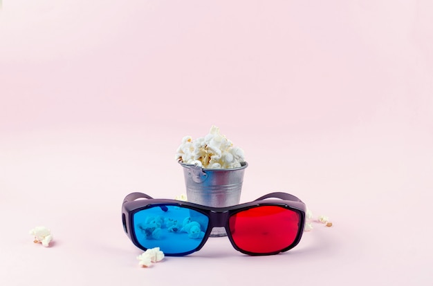 Popcorn in een emmer en 3D-bril op roze