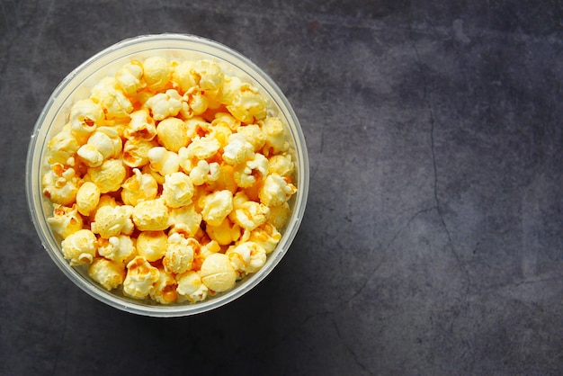 popcorn in een kom op zwarte tegelsachtergrond