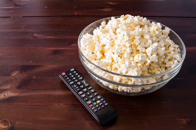 Popcorn in glazen kom en afstandsbediening