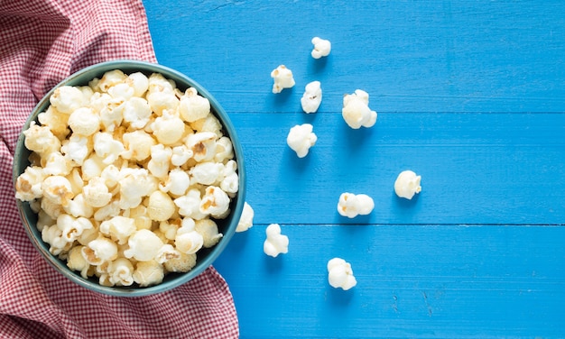 popcorn in kom op blauwe houten achtergrond, hoogste mening