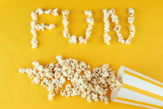 Popcorn inscription fun. The concept of home movies and movies in the cinema. popcorn from corn kernels.