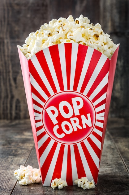 Popcorn inside the packaging striped on wooden table