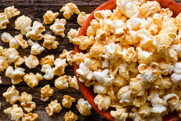 Popcorn met karamel op houten dichte omhooggaand als achtergrond