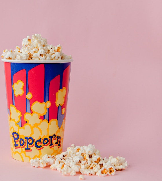 popcorn on a pastel pink background and a place for text. flat lay. copyspace. cinema concept. background
