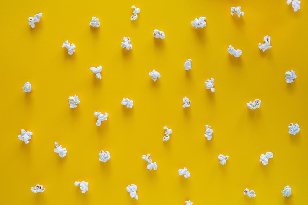 Popcorn pattern on yellow background top view contrast concept popcorn on color background