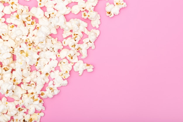 Popcorn on pink background. Movie or TV background, border, frame. Top view Copy space