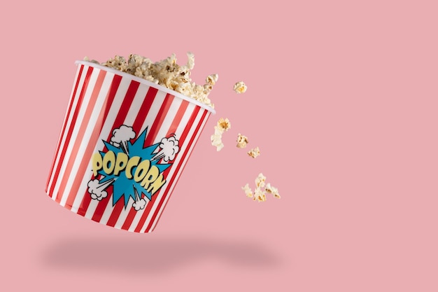 Popcorn in red and white bucket on the pink background