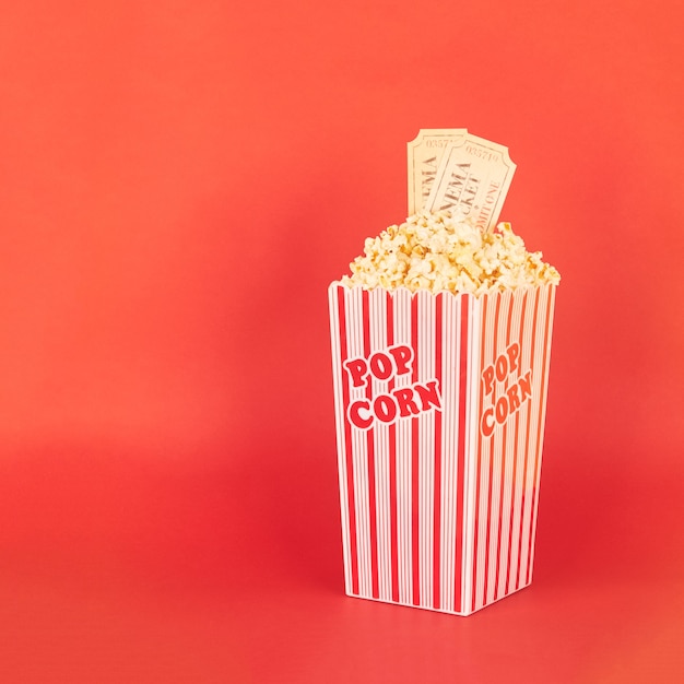 Popcorn in red and white bucket with cinema tickets