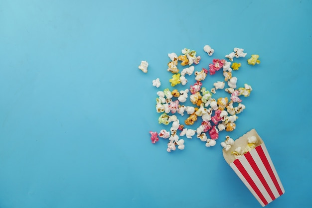 popcorn spilling from a paper container on wooden background