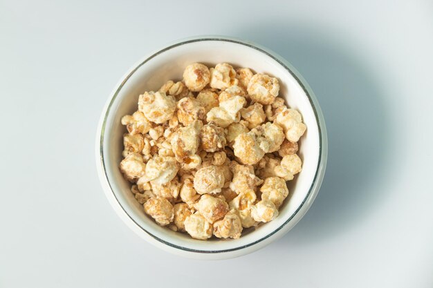 Foto popcorn al gusto di caramello al burro su una ciotola bianca e sfondo bianco