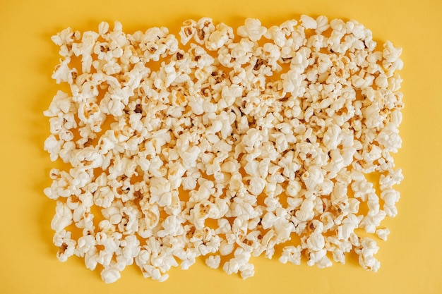 Popcorn on a yellow background as a background image. Top view. Copy, empty space for text.