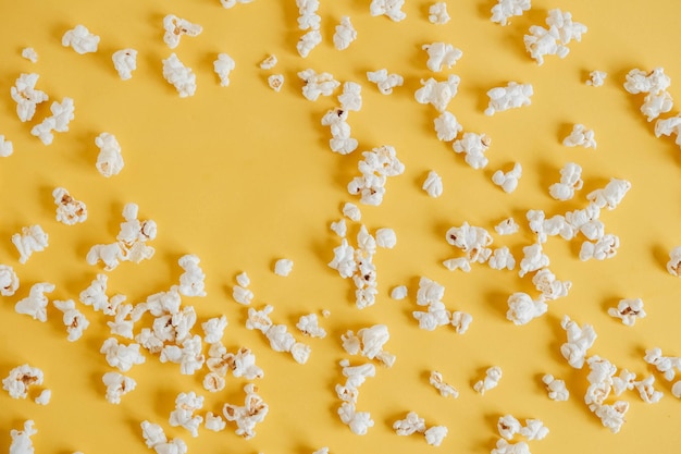 Popcorn on a yellow background as a background image. Top view. Copy, empty space for text.