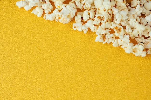 Popcorn on a yellow background. the concept of home cinema and films in the cinema.