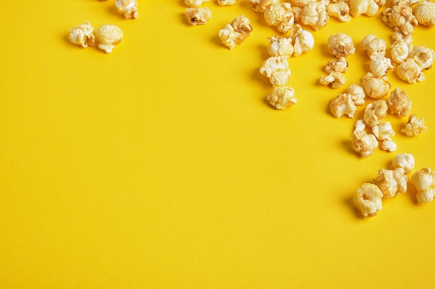 Photo popcorn on yellow background. popcorn pattern. top view, copy space