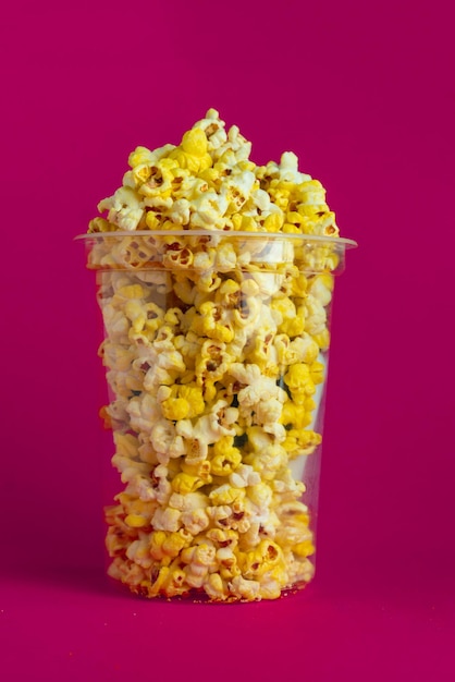 Popcornemmer om bioscoopfilm op gekleurde achtergrond te bekijken
