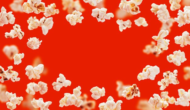 Popcornframe, vliegende die popcorn op rood wordt geïsoleerd