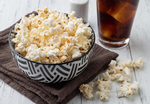 Popcorns op een kom met zout over houten tafel