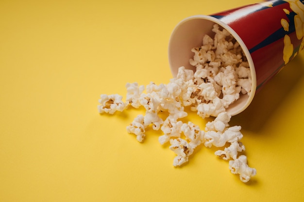 Popcornsnack in een kopje op een gele achtergrond