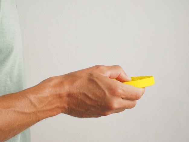 Photo popit game. close up male hands playing with yellow pop it fidget toy, stress anxiety relief.