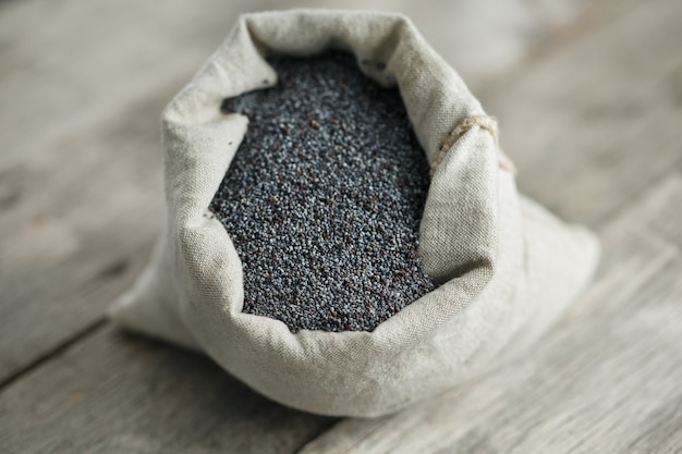 Poppy seeds in a burlap bag. The tasty and useful seeds rich with protein and oils.