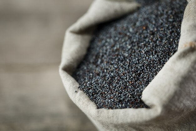 Poppy seeds in a burlap bag. The tasty and useful seeds rich with protein and oils.